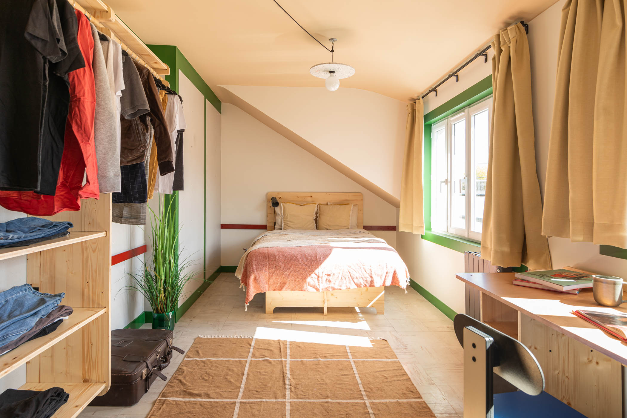 Chambre de coliving Cohabs aménagée avec mobilier sur-mesure fabriqué en série : lit, bureau, penderie et rangements en bois verni teinté