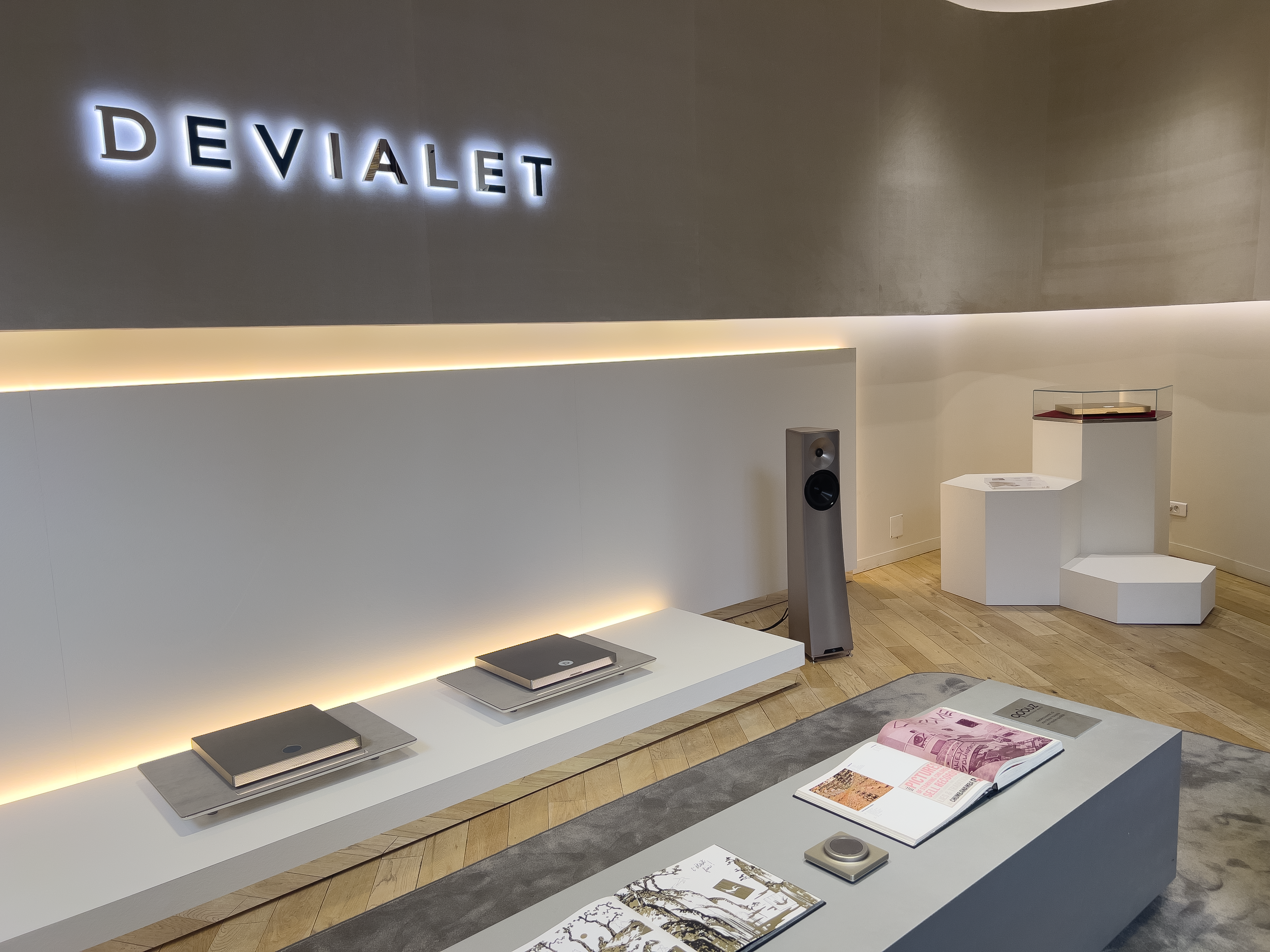 Ensemble d’agencement pour Devialet Paris avec stratifié blanc effet pierre sans chant visible, socles hexagonaux et rétroéclairage LED intégré