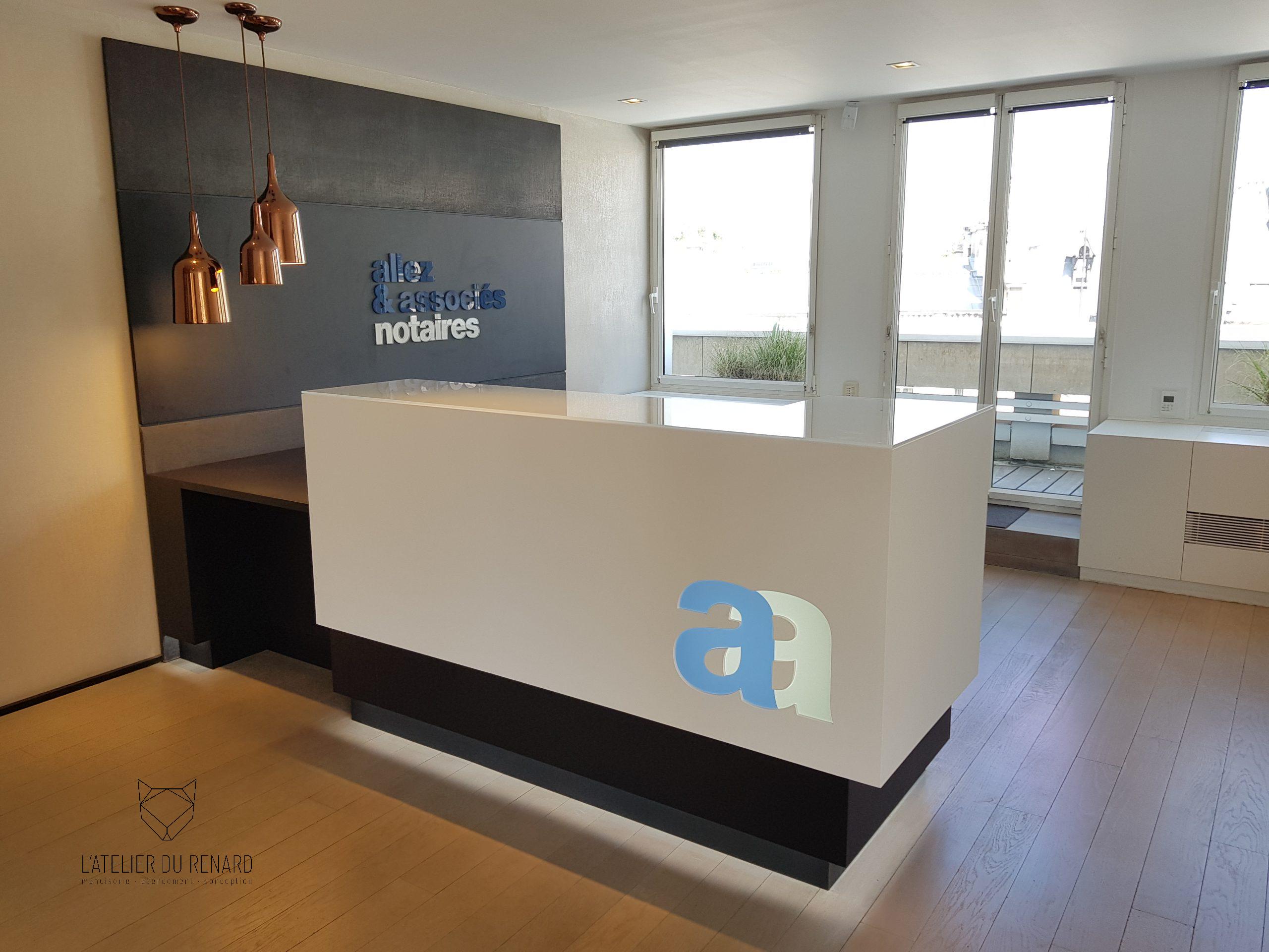 Banque d’accueil design pour étude notariale à Paris 8e avec laque cabine, logo plexiglas diffusant rétroéclairé et lettrage mural en PMMA